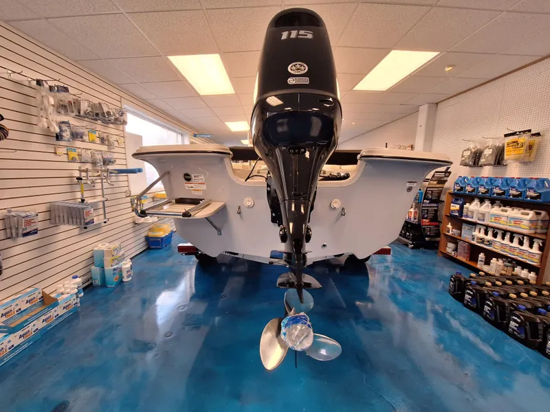 Slide: The Image of 2023 Carolina Skiff 19 LS boat displayed in a showroom with blue flooring. - 5