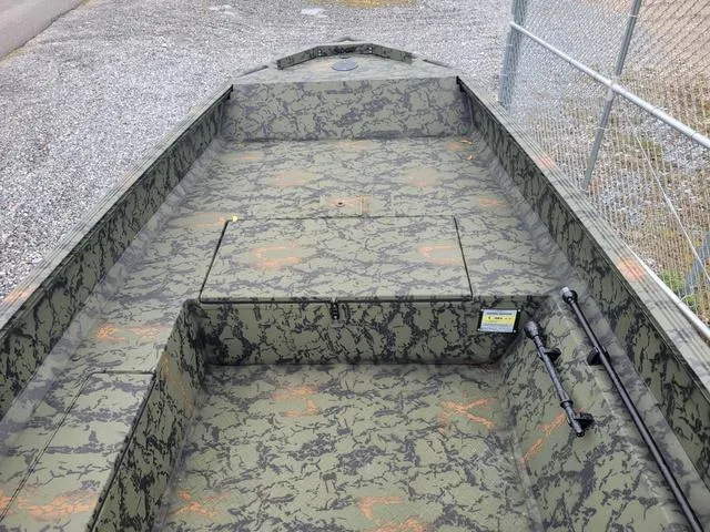 Slide: The Image of 2024 Edge Duck Boats 653DB with camouflage interior, parked near a chain-link fence. - 9