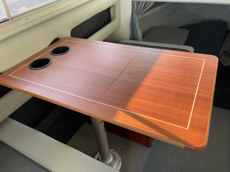 Slide: The Image of 2024 KingFisher 2725 Weekender boat interior with wooden table and cup holders. - 15