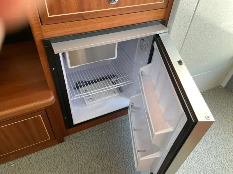 Slide: The Image of 2024 KingFisher 2725 Weekender boat interior with open mini fridge. - 18