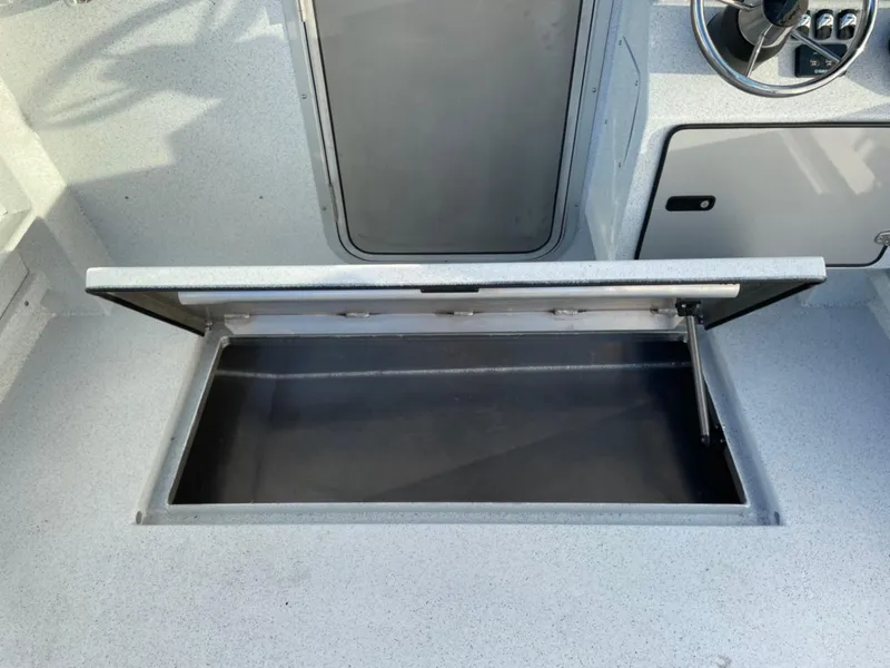 Slide: The Image of 2024 KingFisher 2725 Weekender boat interior with open storage compartment. - 23