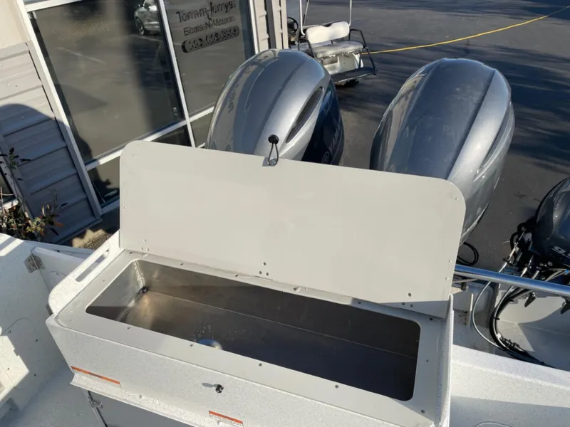 Slide: The Image of 2024 KingFisher 2725 Weekender boat with open storage compartment and dual outboard motors. - 24