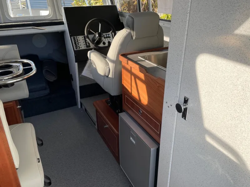 Slide: The Image of 2024 KingFisher 2725 Weekender boat interior with steering wheel and seating. - 9