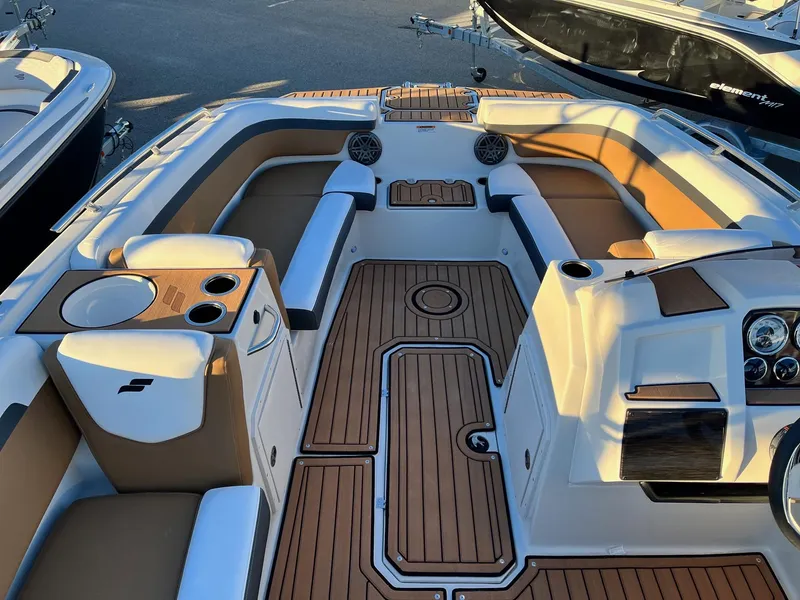 Slide: The Image of 2024 Starcraft SVX 191 boat interior with tan and white seating, wood accents, and cup holders. - 12