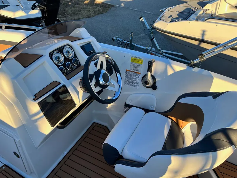 Slide: The Image of 2024 Starcraft SVX 191 boat cockpit with steering wheel and captain's chair. - 7