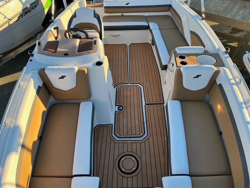 Slide: The Image of 2024 Starcraft SVX 191 boat interior with tan and white seating and wood flooring. - 21