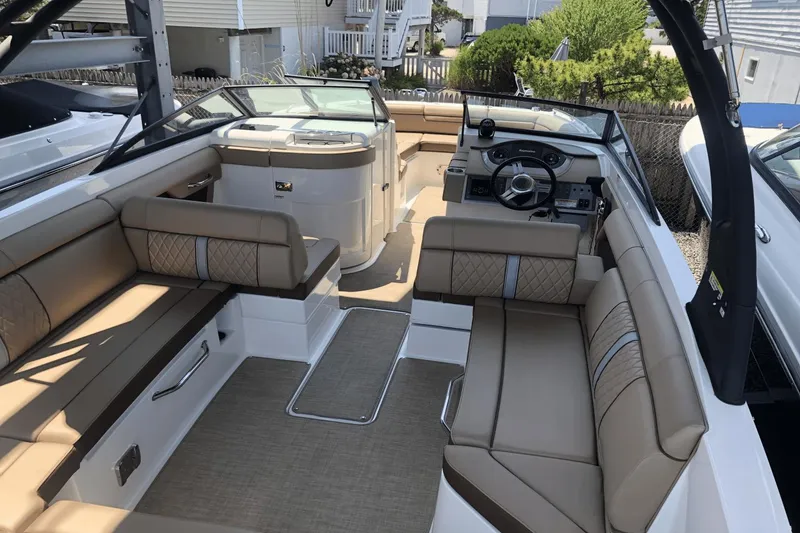 Slide: The Image of 2017 Sea Ray SDX 270 boat interior with tan seating and modern dashboard. - 13