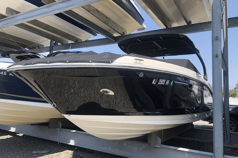Slide: The Image of 2017 Sea Ray SDX 270 boat on a storage rack, black and white exterior. - 0