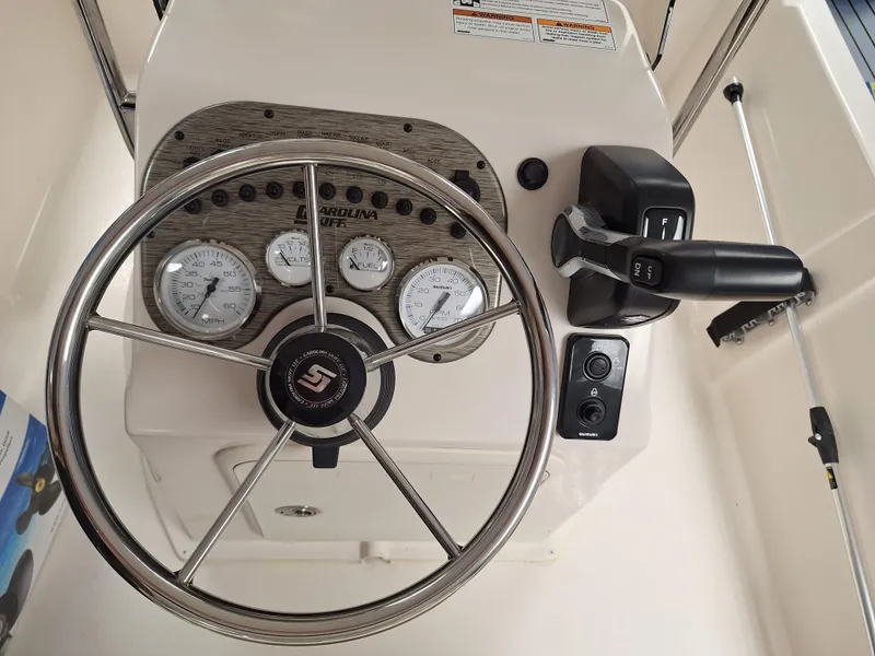 Slide: The Image of 2023 Carolina Skiff 178 JLS boat dashboard with steering wheel and control panel. - 3