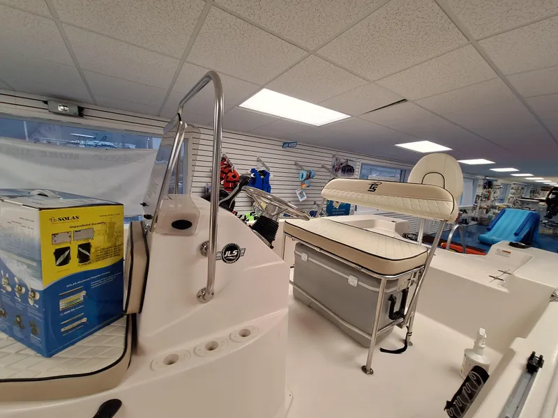 Slide: The Image of 2023 Carolina Skiff 178 JLS boat interior in showroom with seating and equipment. - 5
