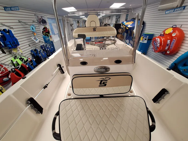 Slide: The Image of 2023 Carolina Skiff 178 JLS boat interior with seating and console, displayed in a showroom. - 9