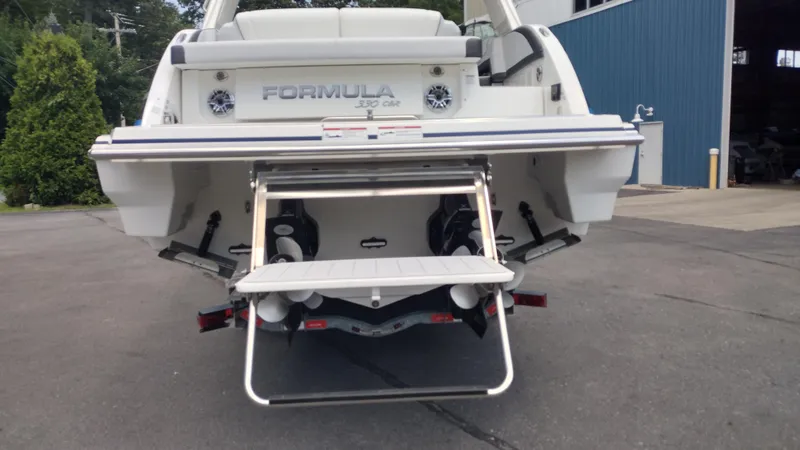 Slide: The Image of Rear view of a 2026 Formula 330 CBR boat with swim platform and ladder. - 11