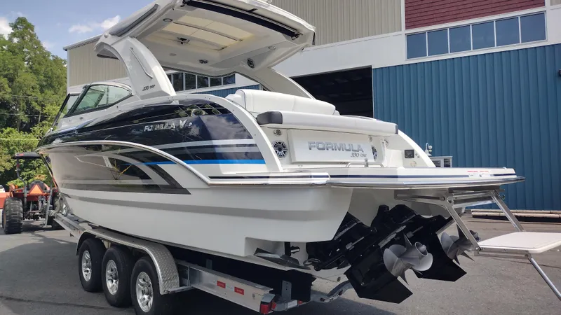 Slide: The Image of 2026 Formula 330 CBR boat on trailer, parked near a blue building. - 6