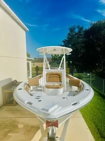 Slide: The Image of 2021 Sea Hunt 234 Ultra boat with T-top and seating, parked outdoors. - 3