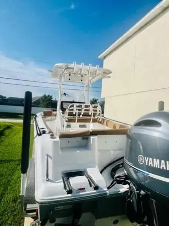Slide: The Image of 2021 Sea Hunt 234 Ultra boat with Yamaha engine, docked near a house. - 5