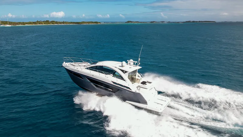Slide: The Image of 2019 Cruisers Yachts 50 Cantius speeding on open water near a tropical island. - 13