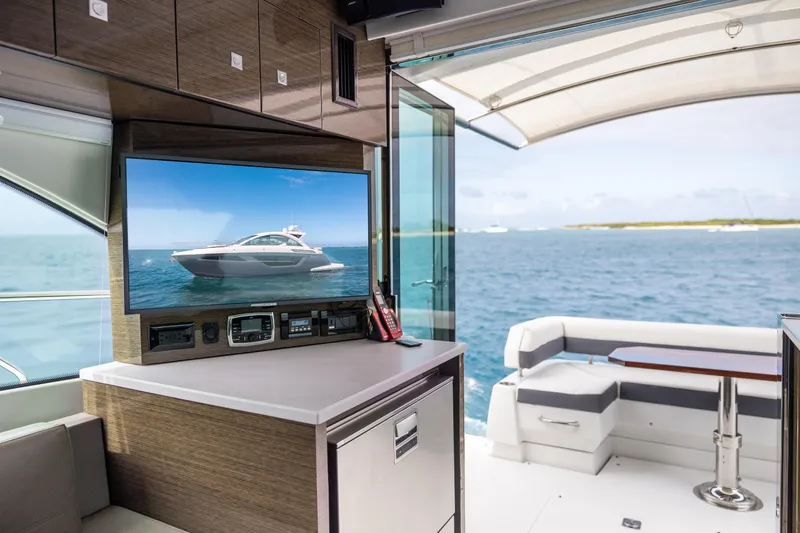 Slide: The Image of Interior of 2019 Cruisers Yachts 50 Cantius with ocean view and TV displaying yacht. - 33