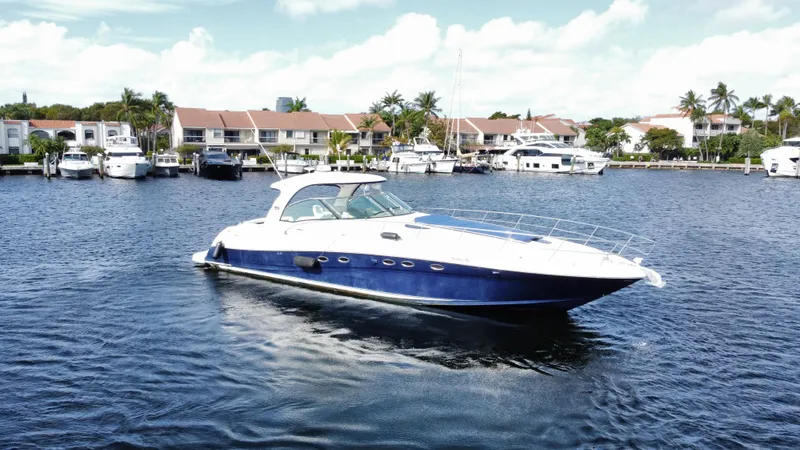 The Image of 2004 Sea Ray 500 Sundancer yacht on calm waters near a marina. - 1