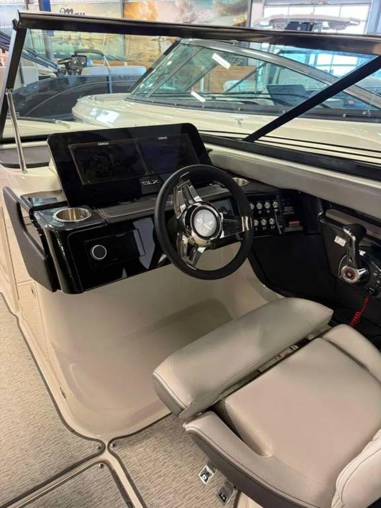 Slide: The Image of 2024 Sea Ray SLX 260 Surf boat interior with modern steering and dashboard controls. - 5