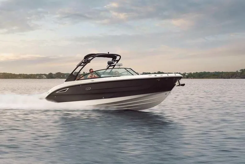 Slide: The Image of 2024 Sea Ray SDX 290 speedboat cruising on a calm lake at sunset. - 4