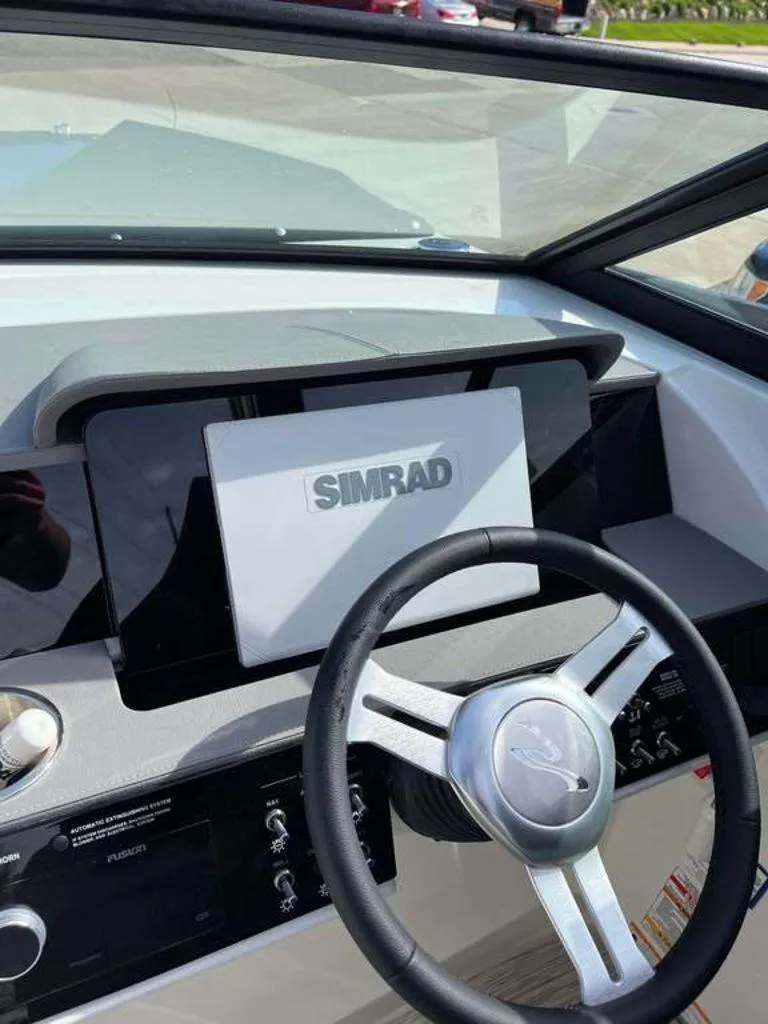 Slide: The Image of 2024 Sea Ray SDX 270 dashboard with Simrad display and steering wheel. - 10