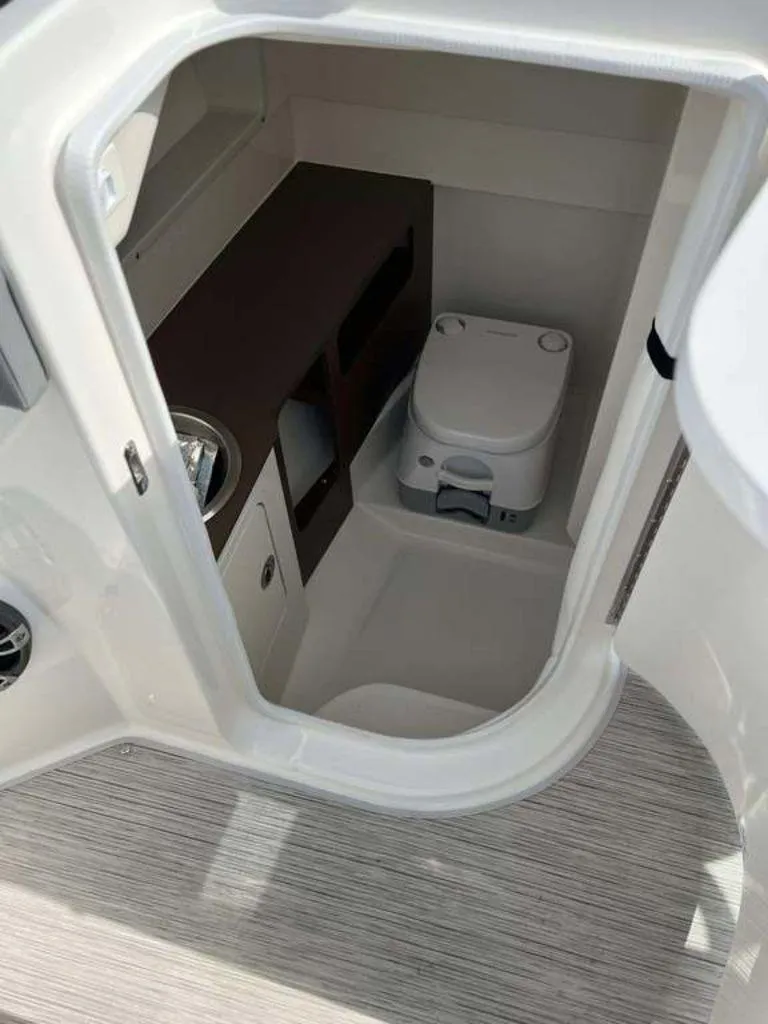 Slide: The Image of 2024 Sea Ray SDX 270 boat interior with compact bathroom and toilet. - 11