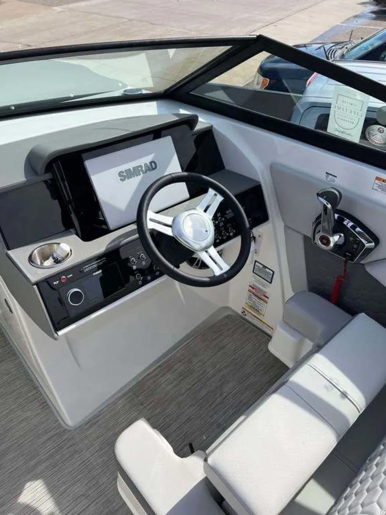 Slide: The Image of 2024 Sea Ray SDX 270 boat dashboard with steering wheel and Simrad display. - 5
