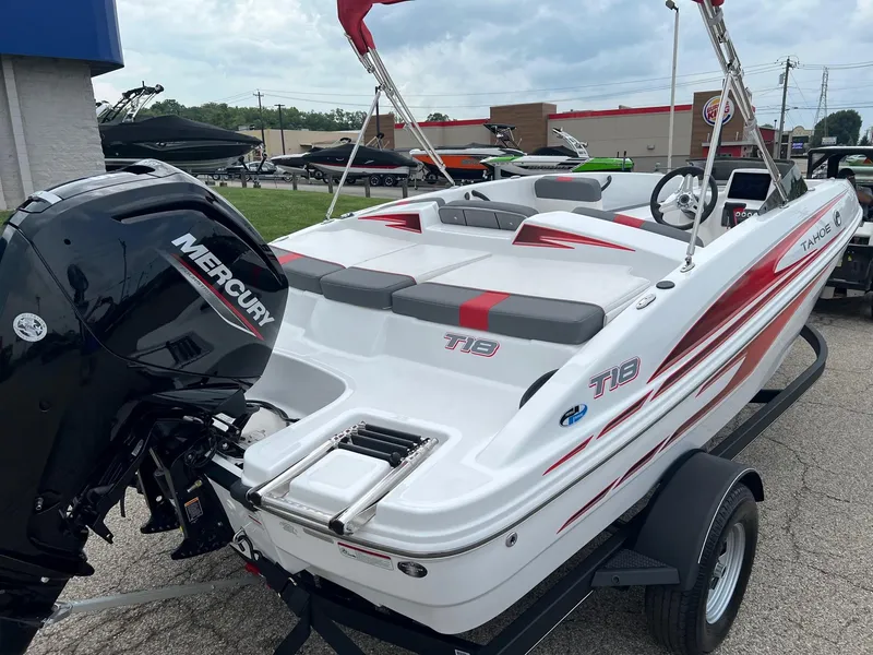 Slide: The Image of 2024 Tahoe T18 boat with Mercury engine, white and red design, parked on trailer. - 4