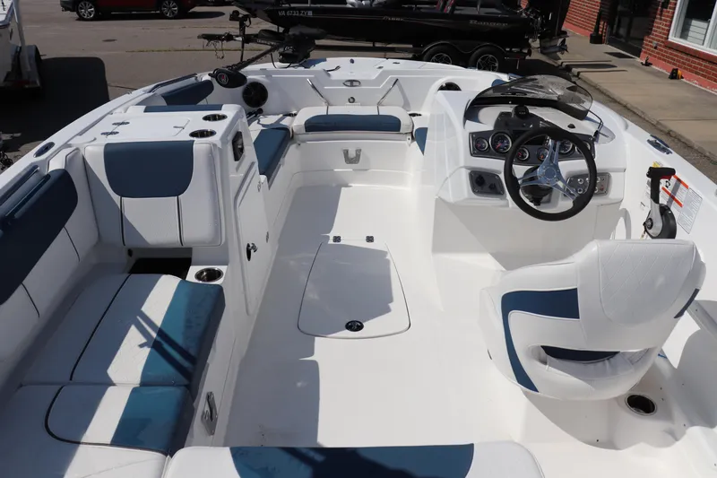 Slide: The Image of 2024 Tahoe 1950 boat interior with white and blue seating, steering wheel, and dashboard controls. - 11