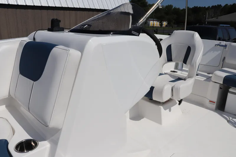 Slide: The Image of 2024 Tahoe 1950 boat interior with white and blue seating, steering console, and cup holder. - 7