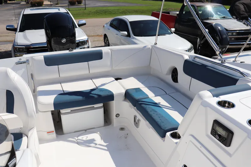 Slide: The Image of 2024 Tahoe 1950 boat interior with white and blue seating, parked cars in background. - 8