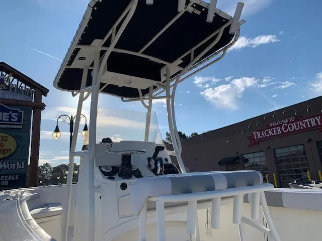 Slide: The Image of 2024 Mako 214 CC boat with T-top and console, displayed outdoors. - 3