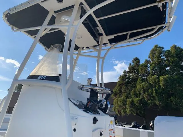 Slide: The Image of 2024 Mako 214 CC center console boat with T-top and steering wheel. - 4