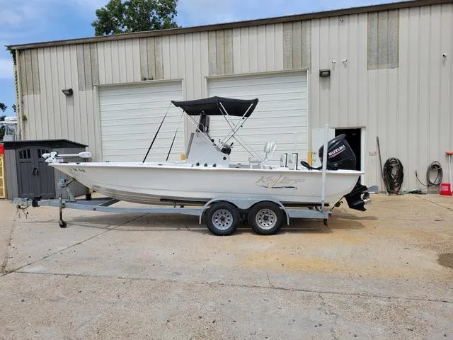 Slide: The Image of 2019 Key Largo 220 BAY boat on a trailer outside a garage. - 3