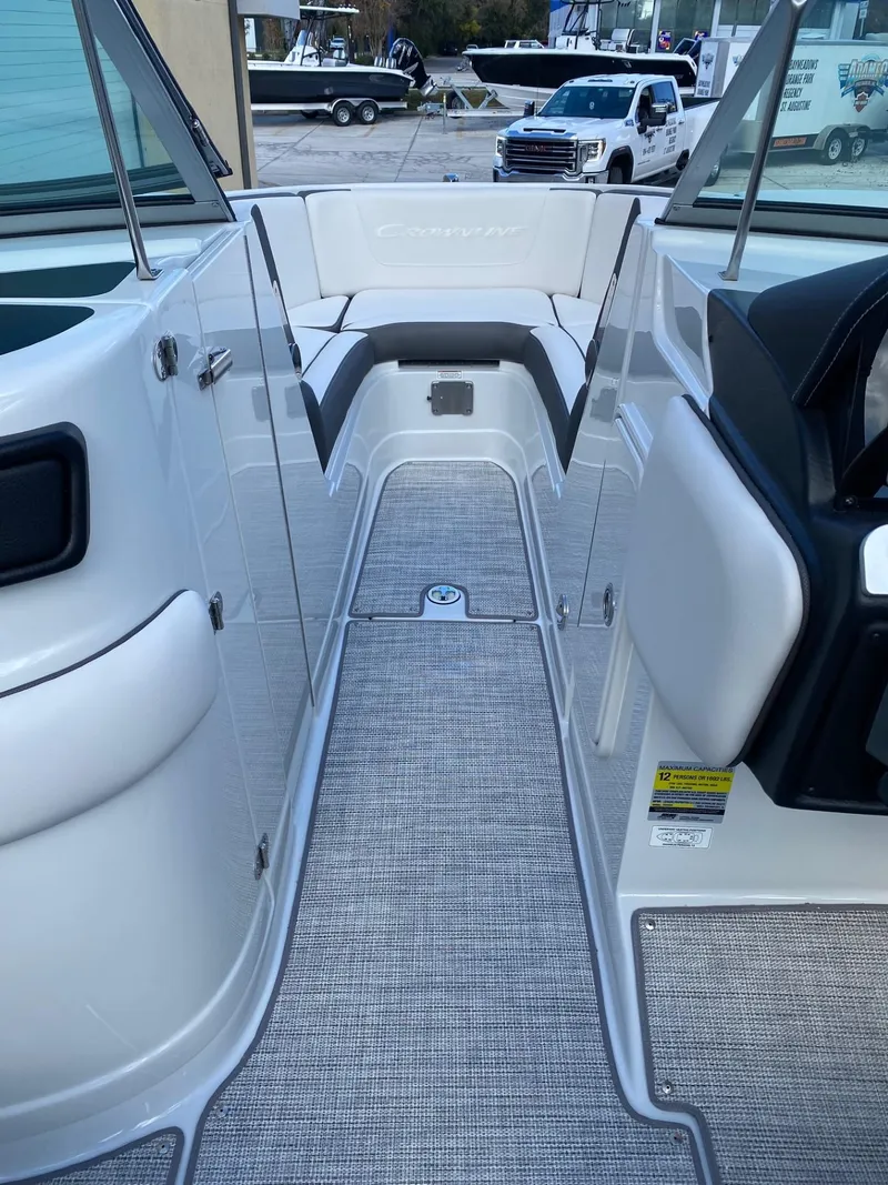 Slide: The Image of 2024 Crownline 250 XSS boat interior with seating and carpeted flooring. - 14