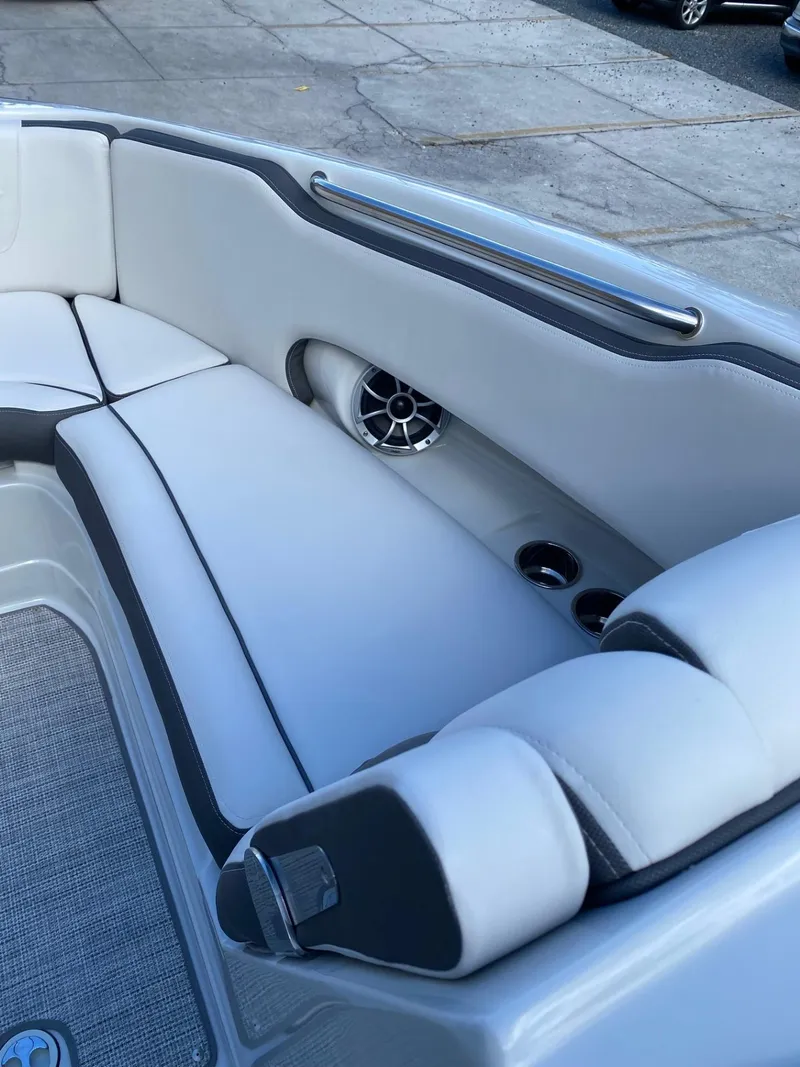 Slide: The Image of 2024 Crownline 250 XSS boat interior with cushioned seating and built-in speakers. - 16