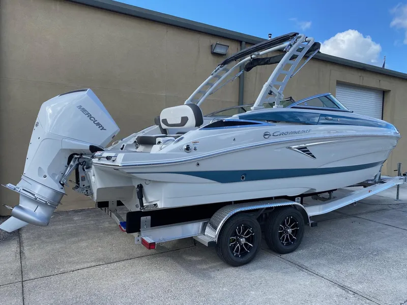 Slide: The Image of 2024 Crownline 250 XSS boat on a trailer with a Mercury outboard motor. - 3