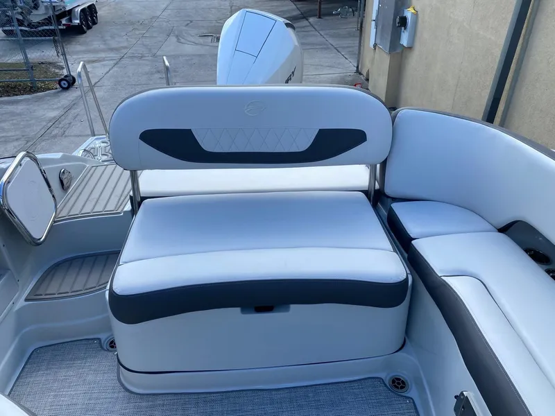 Slide: The Image of 2024 Crownline 250 XSS boat interior seating area with white and gray upholstery. - 9