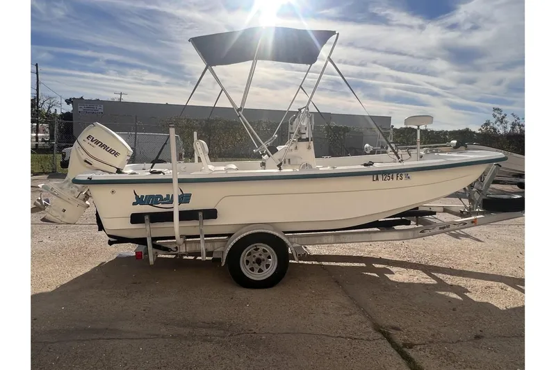 Slide: The Image of 2008 Sundance B18CC boat with Evinrude motor on a trailer, parked outdoors. - 6