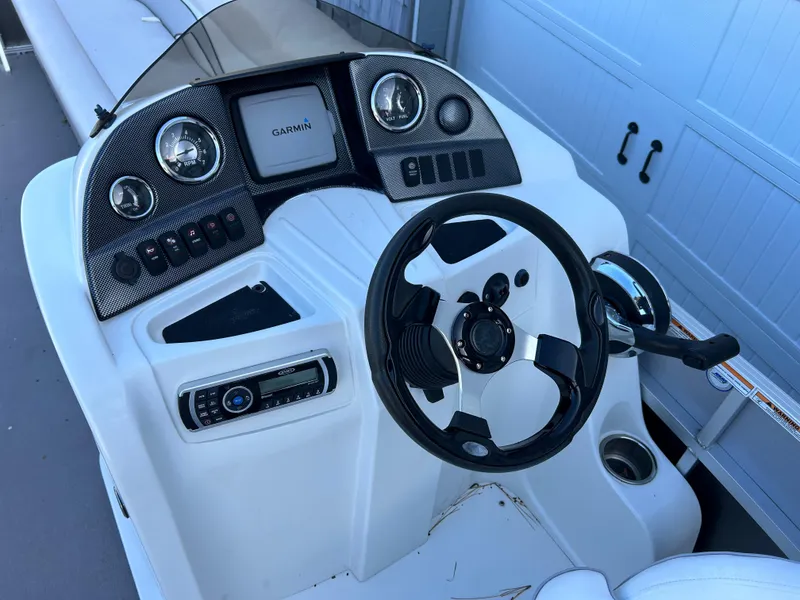 Slide: The Image of 2014 Avalon 2285 Catalina Cruise Twin Toon boat dashboard with Garmin GPS and steering wheel. - 10