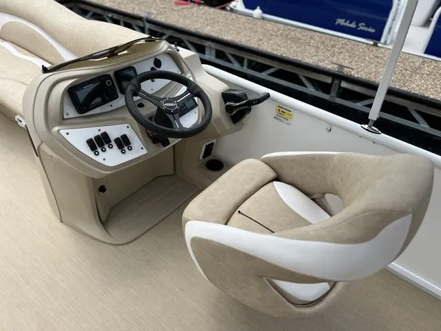 Slide: The Image of 2024 Aloha 230 Club Series boat interior with steering wheel and beige seating. - 10