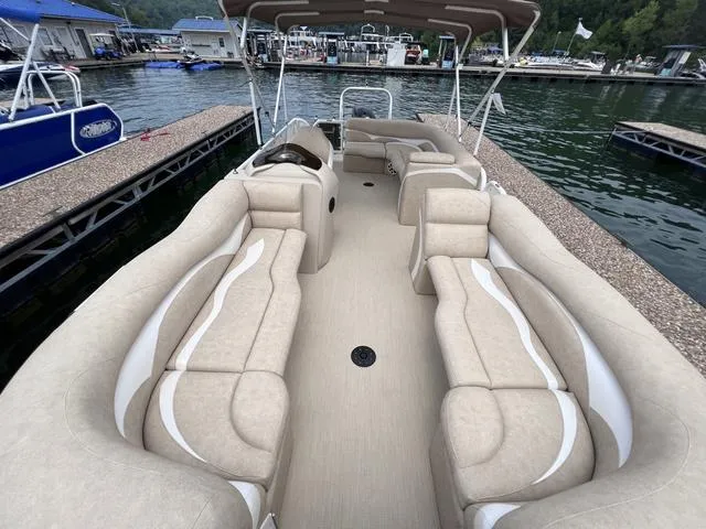 Slide: The Image of 2024 Aloha 230 Club Series pontoon boat with spacious seating, docked at a marina. - 12