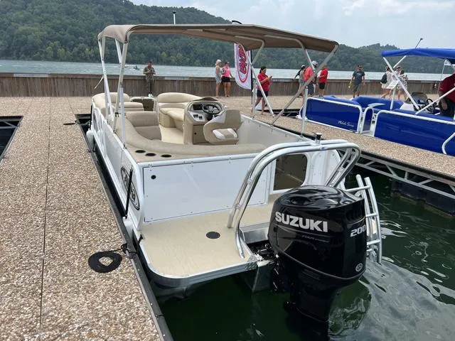 Slide: The Image of 2024 Aloha 230 Club Series boat with Suzuki engine docked by a scenic lake. - 6