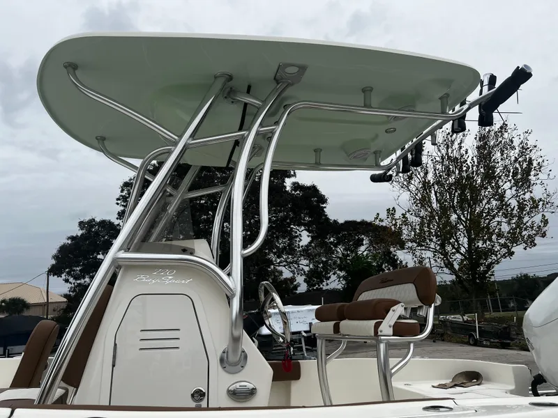 Slide: The Image of 2024 Pioneer 220 Bay Sport boat with T-top and seating, overcast sky. - 11