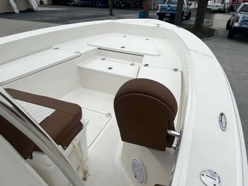Slide: The Image of 2024 Pioneer 220 Bay Sport boat interior with brown seating and storage compartments. - 15