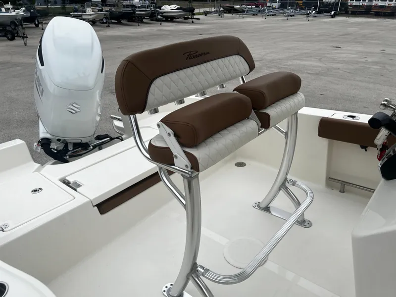 Slide: The Image of 2024 Pioneer 220 Bay Sport boat with brown and white seating, Suzuki outboard motor. - 16