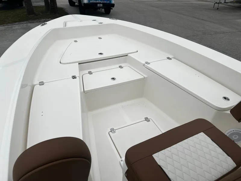 Slide: The Image of 2024 Pioneer 220 Bay Sport boat interior with storage compartments and seating. - 19