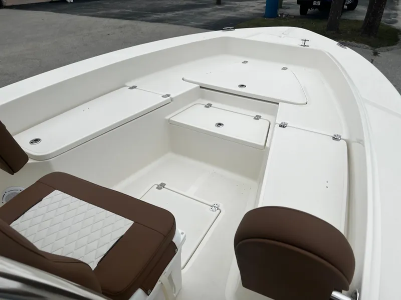 Slide: The Image of 2024 Pioneer 220 Bay Sport boat interior with white deck and brown seating. - 20