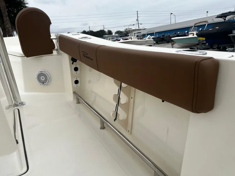 Slide: The Image of 2024 Pioneer 220 Bay Sport boat interior with brown cushioned seating and speaker. - 24