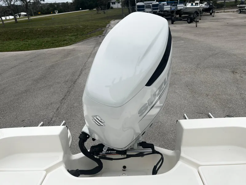 Slide: The Image of 2024 Pioneer 220 Bay Sport boat with Suzuki outboard motor in a parking area. - 30
